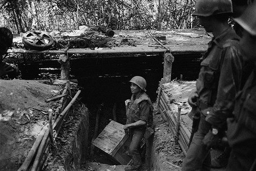 Ho Chi Minh Trail, Laos --- 02/14/71- Ho Chi Minh Trail, Laos: An ARVN soldier hauls out some of the supplies from a bunker discovered on the Ho Chi Minh Trail. North Vietnamese used the bunkers as storage depots and protective cover. Caches of Gasoline, weapons and uniforms have been uncovered. UPI radiophoto by Bob Sullivan. --- Image by © Bettmann/CORBIS